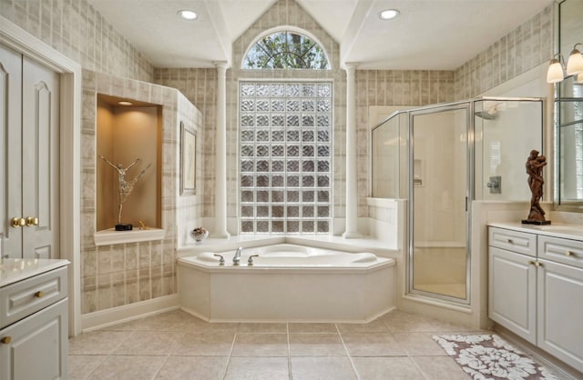 bathroom with vanity, vaulted ceiling, plus walk in shower, and tile patterned flooring