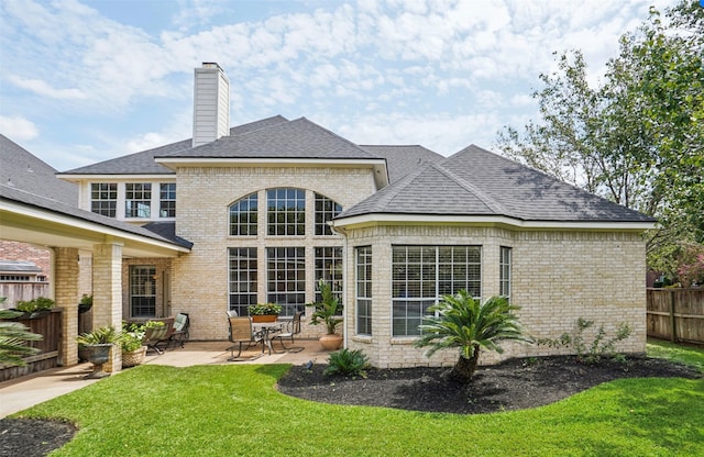 back of property with a patio and a lawn