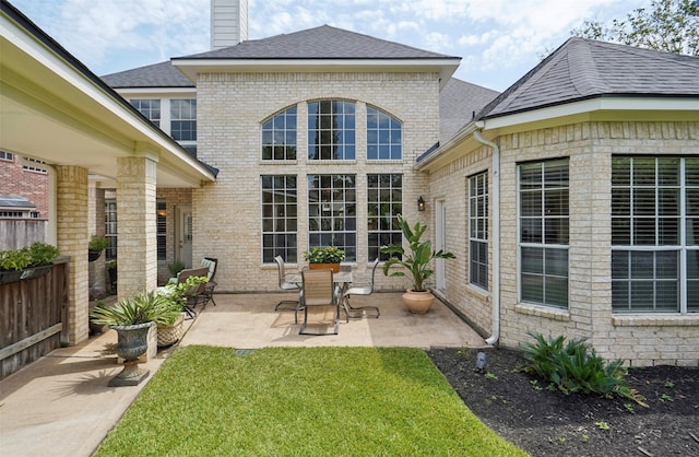 rear view of house with a yard and a patio area