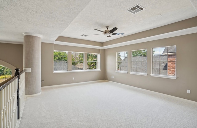 carpeted empty room featuring a textured ceiling, plenty of natural light, and ceiling fan