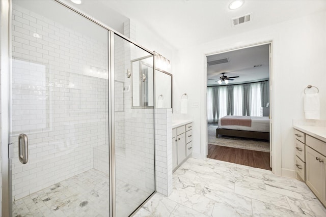 bathroom featuring ceiling fan, a shower with shower door, and vanity