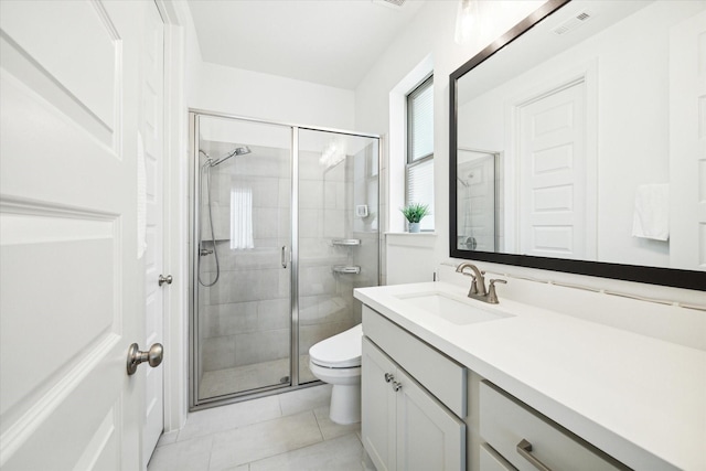 bathroom featuring toilet, tile patterned floors, a shower with shower door, and vanity