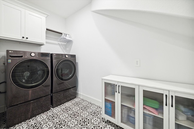 clothes washing area featuring cabinets, independent washer and dryer, and light tile patterned floors