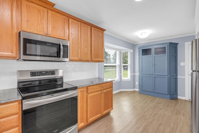 kitchen featuring light wood-type flooring, appliances with stainless steel finishes, tasteful backsplash, and ornamental molding