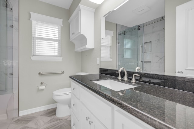 bathroom featuring a shower with door, vanity, and toilet