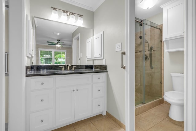 bathroom with a shower with door, tile patterned floors, toilet, ceiling fan, and vanity