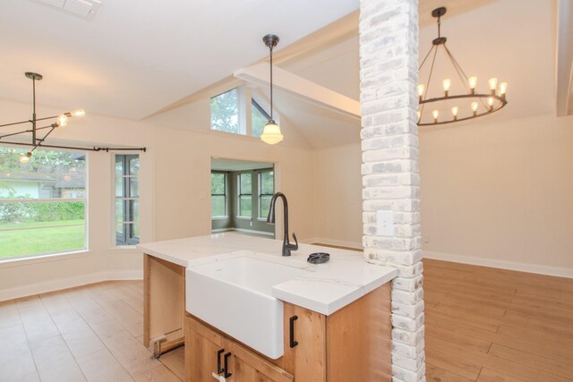 kitchen featuring vaulted ceiling with beams, brick wall, and pendant lighting