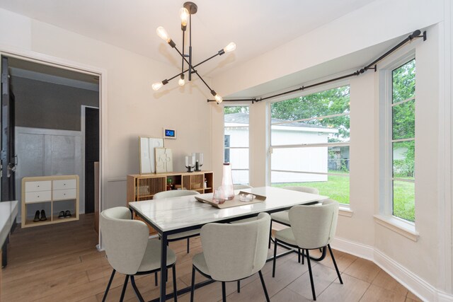 dining area with an inviting chandelier and light hardwood / wood-style flooring