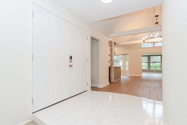 tiled foyer with lofted ceiling with beams and a notable chandelier