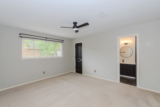 unfurnished bedroom with carpet flooring, connected bathroom, and ceiling fan