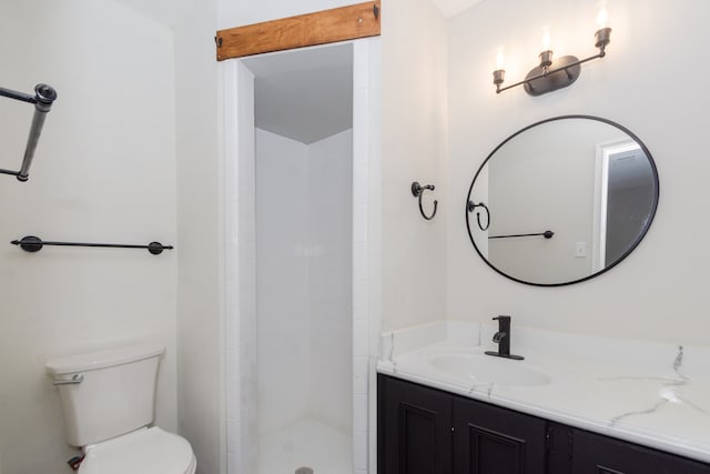 bathroom featuring vanity, tiled shower, and toilet