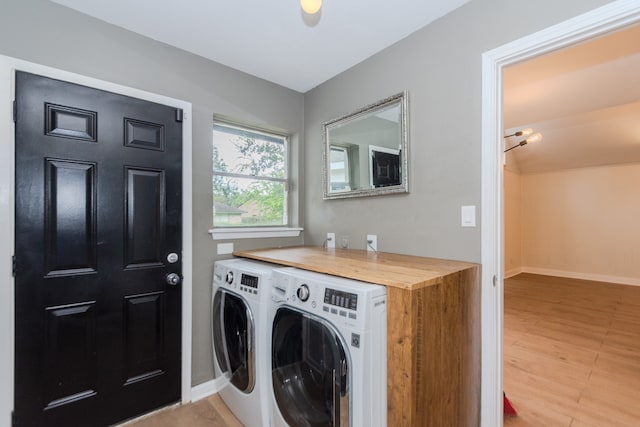 laundry room featuring washer and clothes dryer and light wood-type flooring