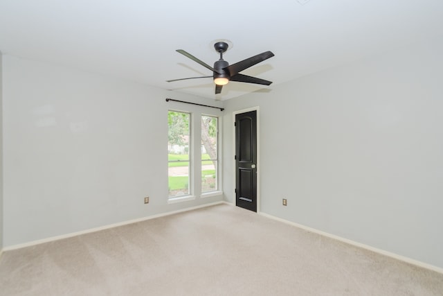 carpeted spare room featuring ceiling fan