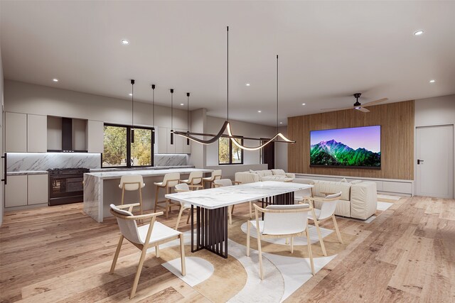 kitchen featuring a kitchen breakfast bar, decorative backsplash, a spacious island, and light wood-type flooring