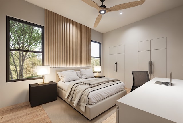 bedroom with light wood-type flooring, a ceiling fan, recessed lighting, and two closets