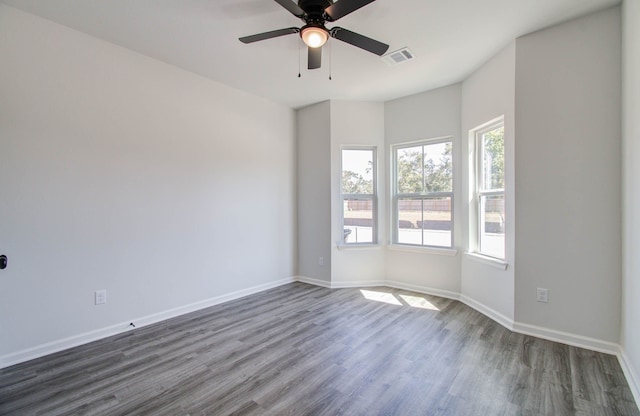 empty room with ceiling fan and dark hardwood / wood-style floors