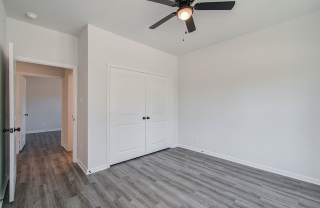 unfurnished bedroom featuring ceiling fan, a closet, and hardwood / wood-style floors