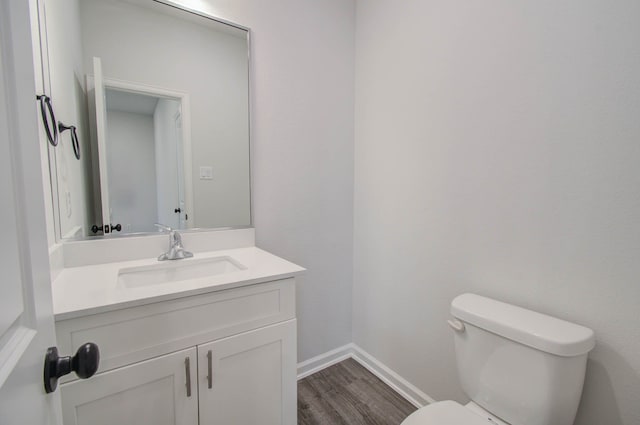 bathroom featuring vanity, toilet, and hardwood / wood-style flooring