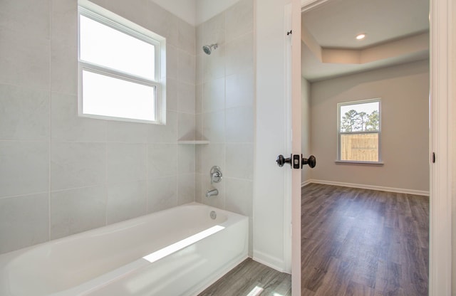 bathroom with wood-type flooring and tiled shower / bath combo