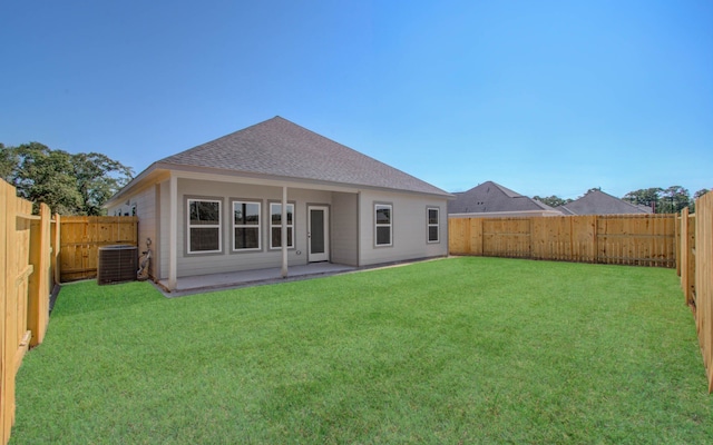 rear view of house with a lawn, a patio area, and central air condition unit