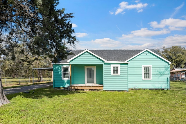 back of house featuring a yard and a carport