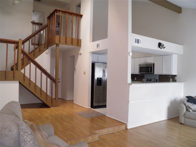 living room featuring light hardwood / wood-style flooring and high vaulted ceiling