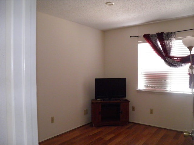 unfurnished living room with hardwood / wood-style flooring and a textured ceiling