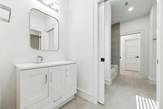 bathroom featuring tile patterned flooring, bathtub / shower combination, and vanity