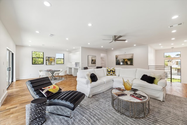 living room featuring light hardwood / wood-style floors and ceiling fan