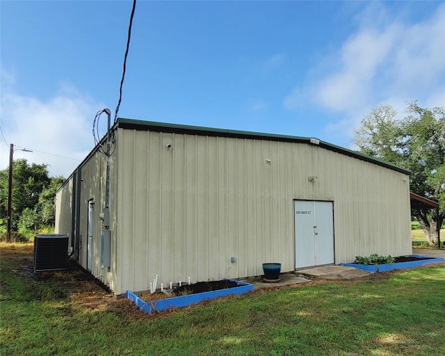 view of pole building featuring a lawn and central air condition unit