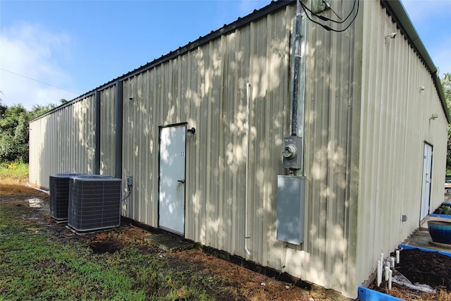 back of property with an outdoor structure and central air condition unit