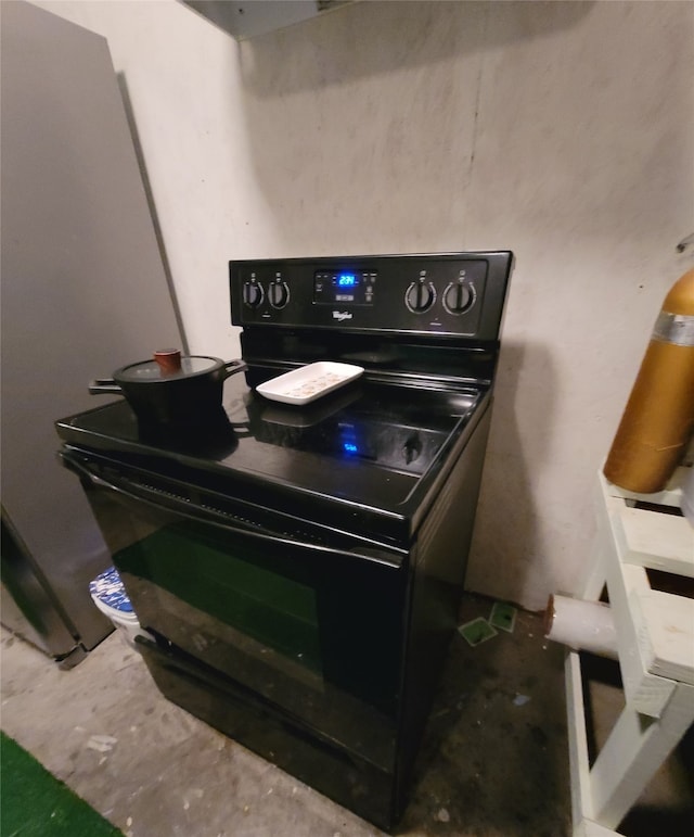 interior details with concrete flooring and black electric range