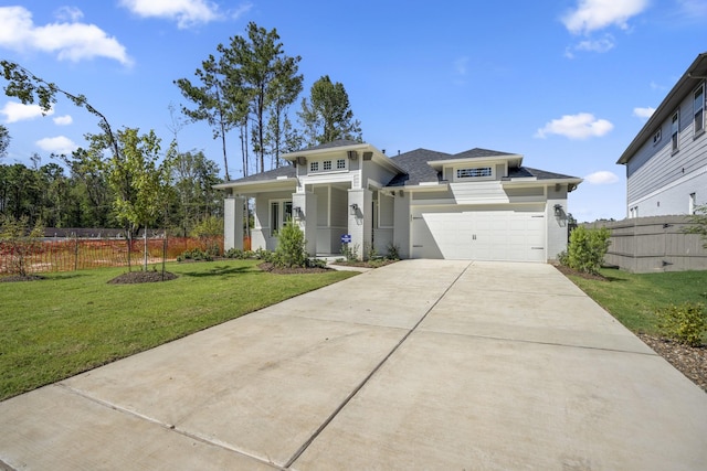 prairie-style house featuring driveway, a garage, fence, and a front lawn