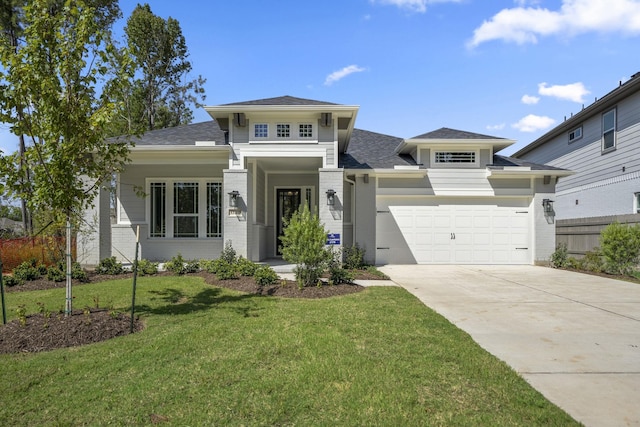 prairie-style home with driveway, an attached garage, fence, a front lawn, and brick siding