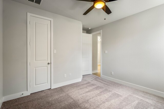 unfurnished bedroom with light colored carpet and ceiling fan