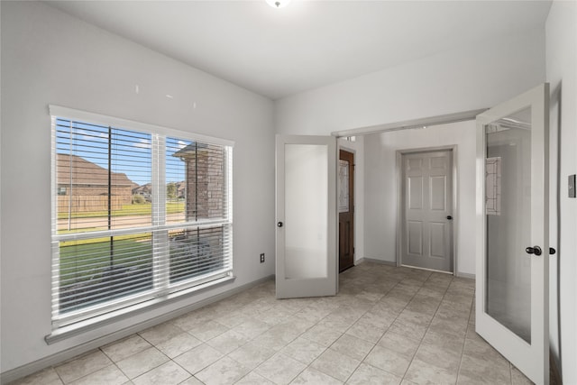 unfurnished bedroom featuring light tile patterned floors and french doors