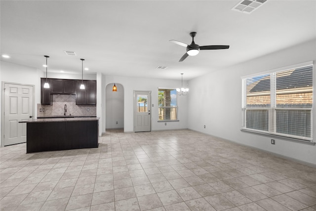 kitchen featuring open floor plan, a kitchen island, visible vents, and dark brown cabinetry