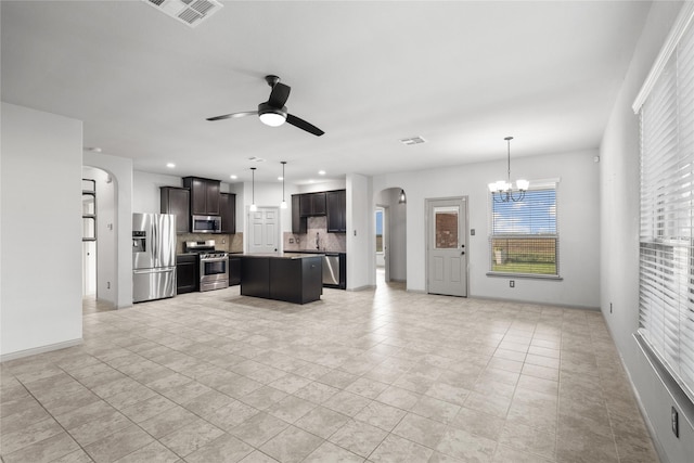 unfurnished living room featuring arched walkways, ceiling fan with notable chandelier, a sink, and visible vents