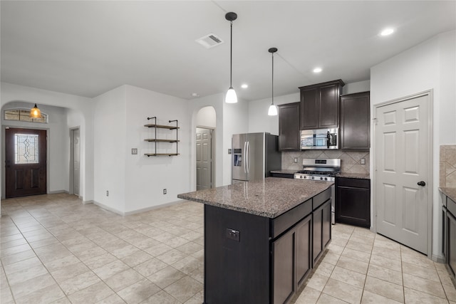 kitchen featuring dark brown cabinets, light tile patterned floors, a kitchen island, stainless steel appliances, and decorative backsplash