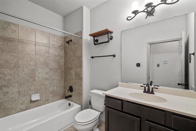 full bathroom featuring vanity, tiled shower / bath combo, toilet, and tile patterned flooring