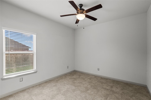 tiled spare room featuring ceiling fan and plenty of natural light