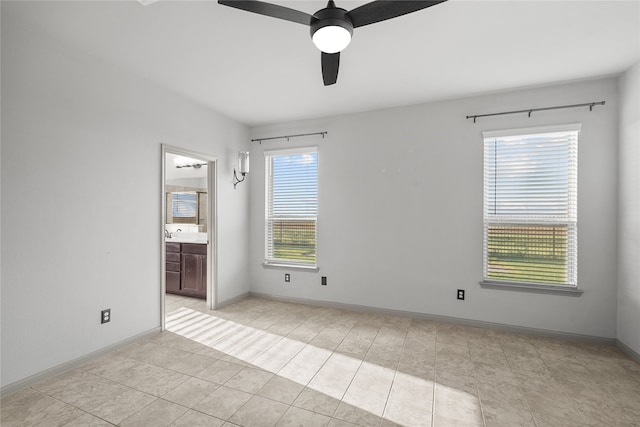 tiled spare room featuring sink and ceiling fan