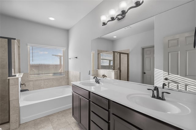 full bath featuring a healthy amount of sunlight, a stall shower, tile patterned flooring, and a sink