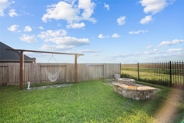 view of yard featuring an outdoor fire pit and a fenced backyard