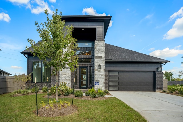 contemporary house featuring a garage and a front lawn