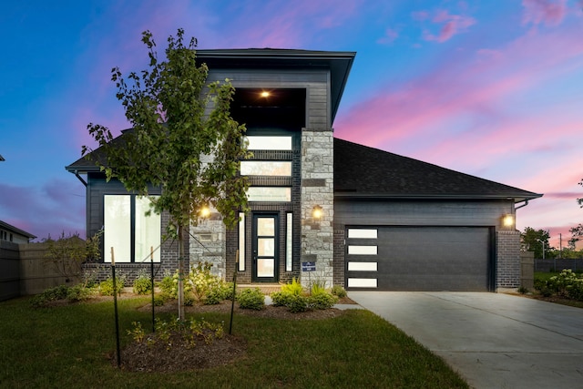 contemporary home with a garage and a lawn