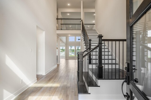 foyer entrance with wood-type flooring and a high ceiling