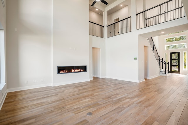 unfurnished living room featuring hardwood / wood-style floors and a high ceiling