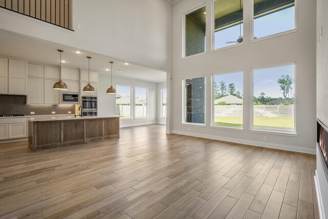 living room featuring light wood-type flooring and a high ceiling