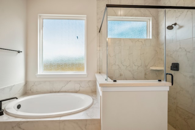 bathroom featuring shower with separate bathtub and a wealth of natural light